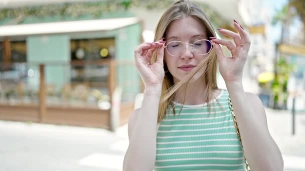 Joven Mujer Rubia Sonriendo Confiada Sacando Gafas Terraza Cafetería — Vídeo de stock