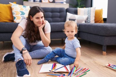 Anne ve oğlu evde oturmuş çizim yapıyorlar.