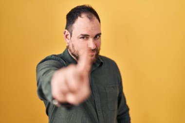 Ayrıca sarı arka planda sakallı iri yarı, ispanyol bir adam parmağını kaldırmış ve kızgın bir ifade takınıyor. 