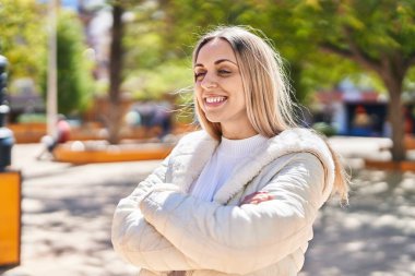 Young woman smiling confident standing with arms crossed gesture at park