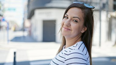 Orta Doğulu bir kadın sokakta kendinden emin gülümsüyor