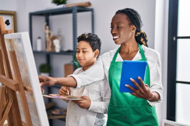 African american mother and son art student and teacher drawing and using touchpad at art studio