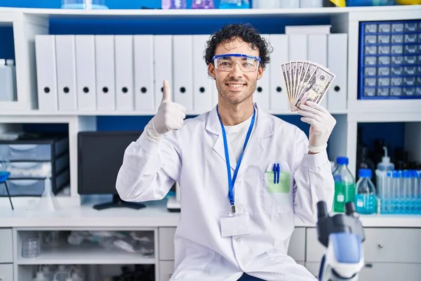 Hombre Hispano Trabajando Laboratorio Científico Sosteniendo Dinero Sonriendo Feliz Positivo — Foto de Stock