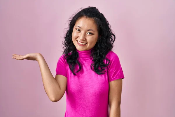 Mladá Asijská Žena Stojící Nad Růžovým Pozadím Úsměvem Veselý Prezentaci — Stock fotografie