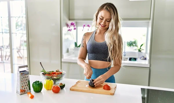 Young Woman Smiling Confident Cutting Avocado Salad Kitchen — Stockfoto