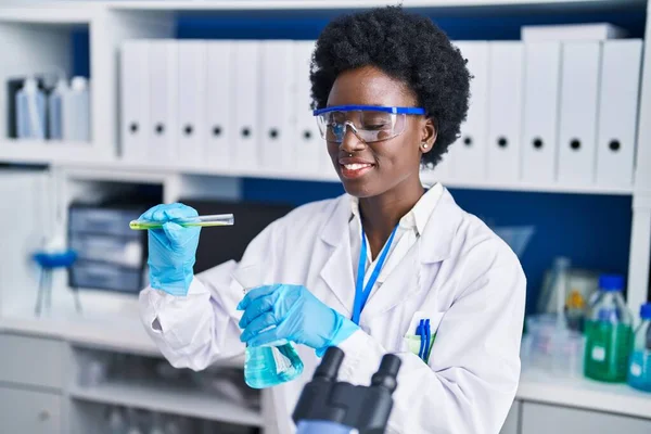 実験室で液体を測定する若いアフリカ系アメリカ人女性科学者 — ストック写真