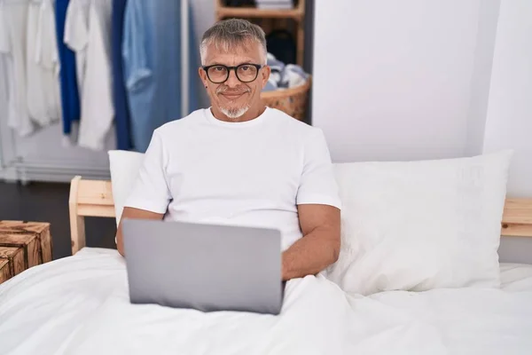 Yatak Odasında Dizüstü Bilgisayar Kullanan Orta Yaşlı Kır Saçlı Bir — Stok fotoğraf