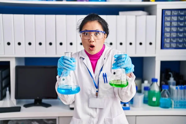 科学研究所で働く若いアジア人女性は 驚きと驚きの表情 恐怖と興奮した顔で恐怖とショックを受けました — ストック写真