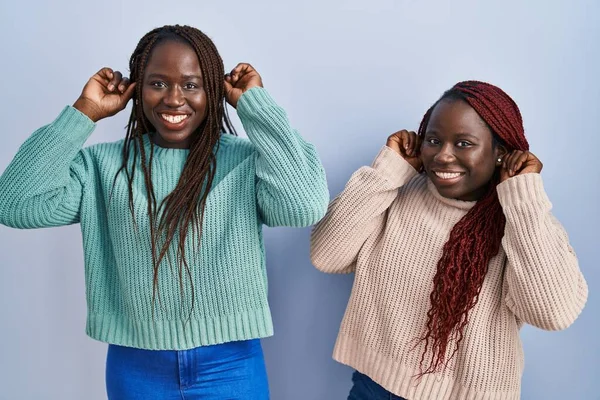 Δύο Αφρικανή Γυναίκα Στέκεται Πάνω Από Μπλε Φόντο Χαμογελώντας Τραβώντας — Φωτογραφία Αρχείου