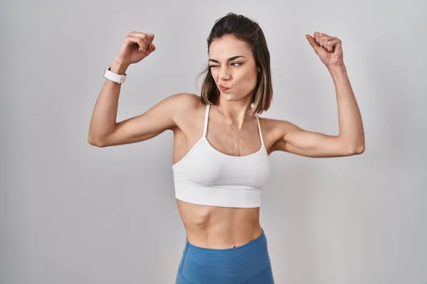 Hispanic Kvinna Bär Sportkläder Över Isolerad Bakgrund Visar Armar Muskler — Stockfoto