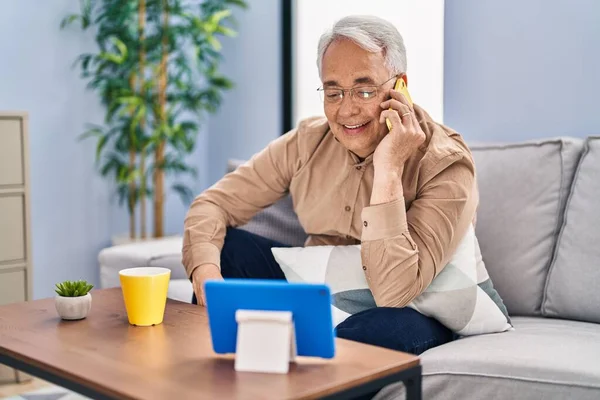 Senior Άνθρωπος Μιλάει Στο Smartphone Βλέποντας Touchpad Στο Σπίτι — Φωτογραφία Αρχείου