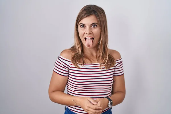 面白い表情で幸せを舌に突き出す孤立した背景の上に立つ若いヒスパニック系の女性 感情の概念 — ストック写真