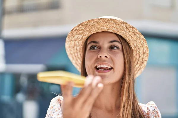 若い女性の観光客を身に着けている夏の帽子スマートフォンで話して通り — ストック写真
