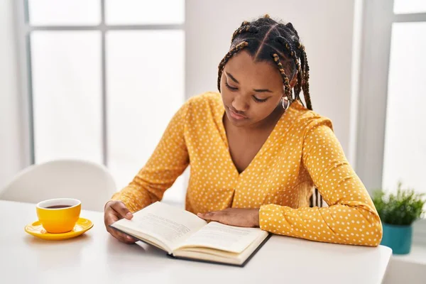 Mujer Afroamericana Leyendo Libro Tomando Café Sentada Mesa Casa —  Fotos de Stock