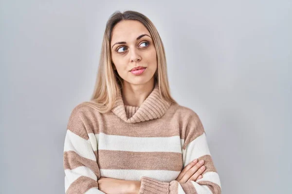 stock image Young blonde woman wearing turtleneck sweater over isolated background looking to the side with arms crossed convinced and confident 