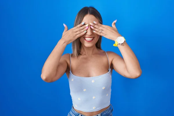 Young Woman Standing Blue Background Covering Eyes Hands Smiling Cheerful — Photo