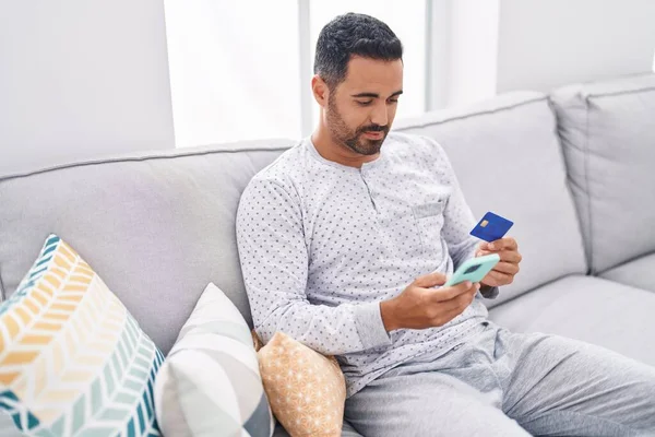Young Hispanic Man Using Smartphone Credit Card Sitting Sofa Home — Stock Photo, Image