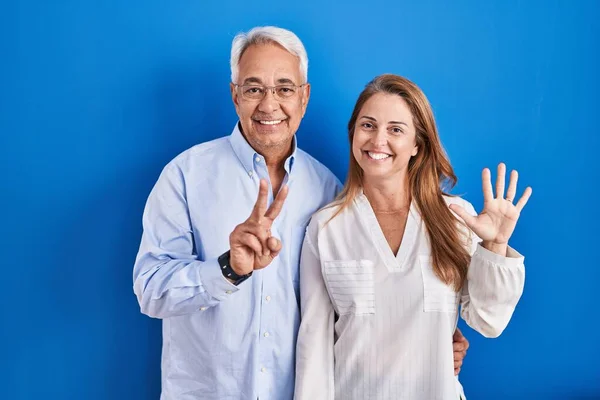 Hispanisches Paar Mittleren Alters Steht Vor Blauem Hintergrund Und Zeigt — Stockfoto