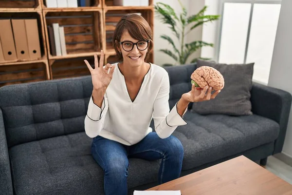 Terapi Ofisinde Çalışan Esmer Bir Kadın Beyni Tutuyor Parmaklarıyla Imza — Stok fotoğraf