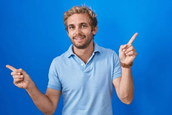 Hombre Caucásico Pie Sobre Fondo Azul Sonriendo Confiado Señalando Con —  Fotos de Stock