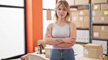 Genç sarışın kadın ecommerce iş işçisi. Ofiste gülümsüyor.