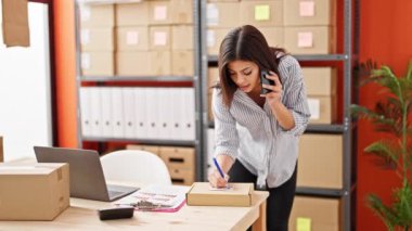 Kafkasyalı genç kadın dış ticaret işçisi ofisteki pakette akıllı telefon yazısıyla konuşuyor.