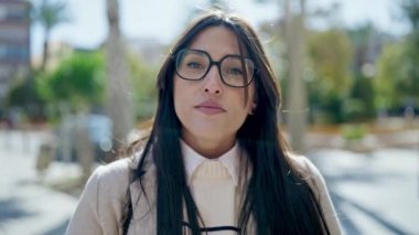 Parkta ciddi bir ifadeyle duran genç, güzel İspanyol kadın.