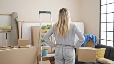 Young blonde woman smiling confident standing at new home