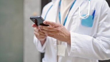 Sokakta akıllı telefon kullanan genç Latin doktor.