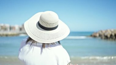 Orta yaşlı İspanyol turist. Bikini giyiyor. Plajda kalp hareketi yapıyor.