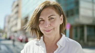 Middle age hispanic woman smiling confident at street