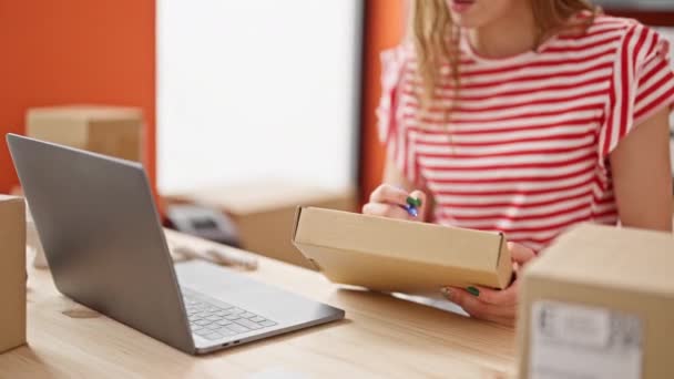 Młoda Blondynka Ecommerce Kobieta Pracownik Pomocą Laptopa Pisanie Opakowaniu Biurze — Wideo stockowe