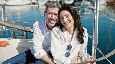 Son sınıf erkek ve kadın çift birbirlerine sarılıyorlar teknede birlikte oturuyorlar.