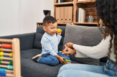 Mother and son having educational therapy at pedagogue center