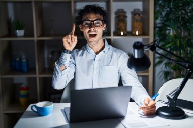 Geceleri ofiste çalışan İspanyol bir adam başarılı bir fikri işaret ediyor. Heyecanlı ve mutlu. Bir numara.. 