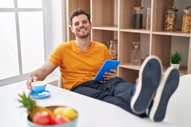 Genç İspanyol dokunmatik adam evde kahve içiyor.