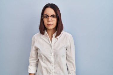 Young hispanic woman standing over white background skeptic and nervous, frowning upset because of problem. negative person. 