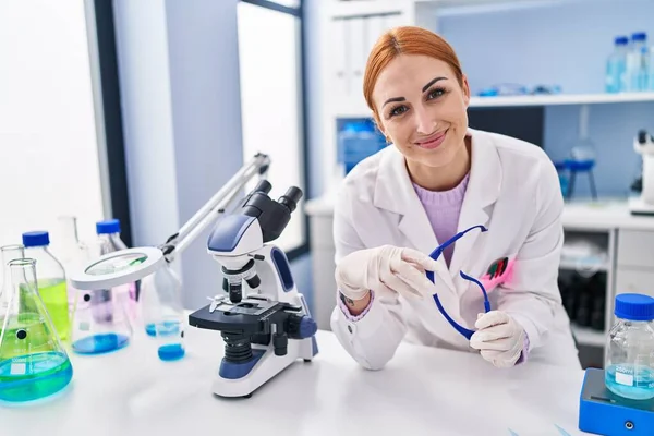 Jovem Cientista Caucasiana Sorrindo Confiante Segurando Óculos Segurança Laboratório — Fotografia de Stock