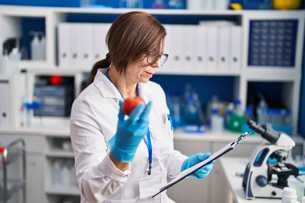 Kobieta Średnim Wieku Naukowiec Trzyma Raport Czytania Jabłek Laboratorium — Zdjęcie stockowe
