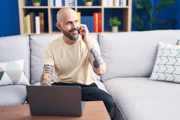 Young Bald Man Talking Smartphone Using Laptop Home — Foto de Stock