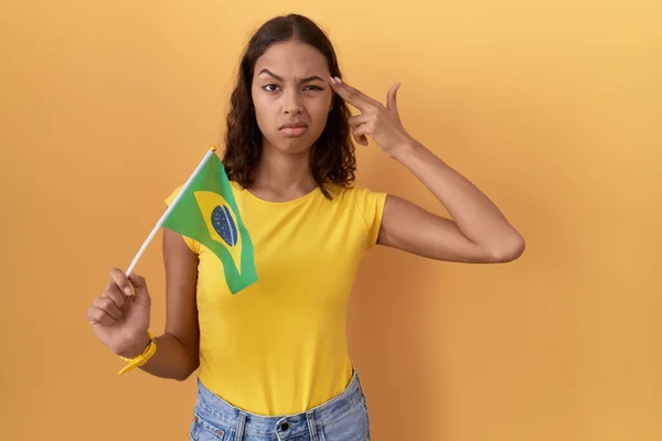 Jovem Hispânica Segurando Bandeira Brasil Atirando Matando Apontando Mão Dedos — Fotografia de Stock