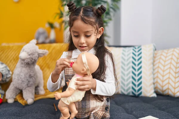 Evdeki Kanepede Oturan Sevimli Spanyol Kız Oyuncak Bebeği Tutuyor — Stok fotoğraf