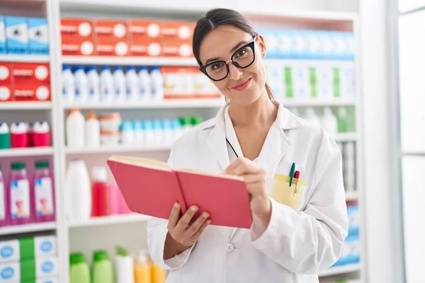 Young Beautiful Hispanic Woman Pharmacist Smiling Confident Writing Notebook Pharmacy — 스톡 사진