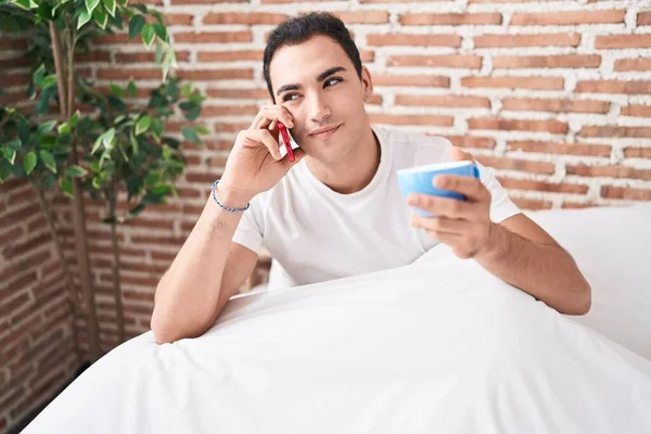 Junger Hispanischer Mann Telefoniert Mit Smartphone Und Trinkt Kaffee Schlafzimmer — Stockfoto