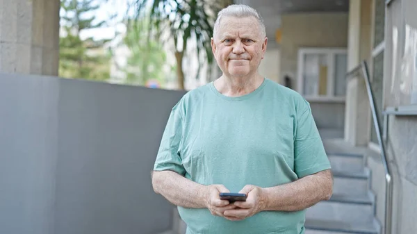 Orta Yaşlı Kır Saçlı Sokakta Gülümseyen Akıllı Telefon Kullanan Bir — Stok fotoğraf
