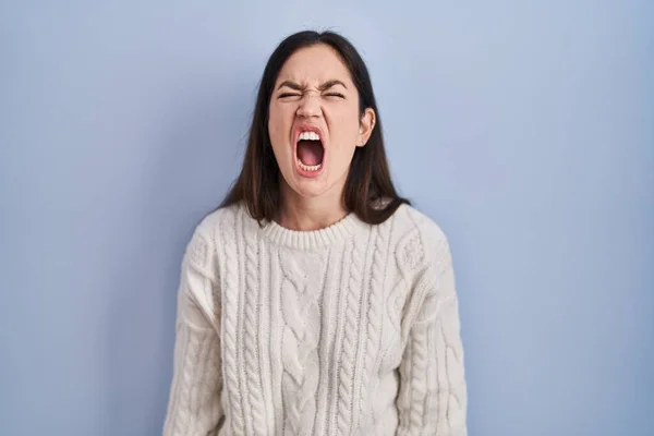 若いブルネットの女性が青の背景に立って怒りと怒りで叫んで フラストレーションと激怒叫んで怒っている 怒りと攻撃的な考え方 — ストック写真