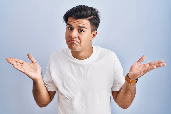 Hispanic Man Standing Blue Background Clueless Confused Expression Arms Hands — Stockfoto