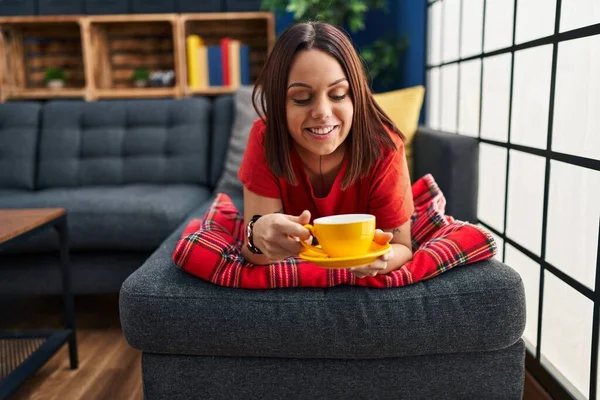 Young Beautiful Hispanic Woman Drinking Coffee Lying Sofa Home — Stockfoto