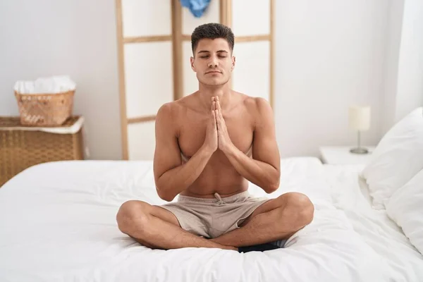 stock image Young hispanic man doing yoga exercise sitting on bed at bedroom