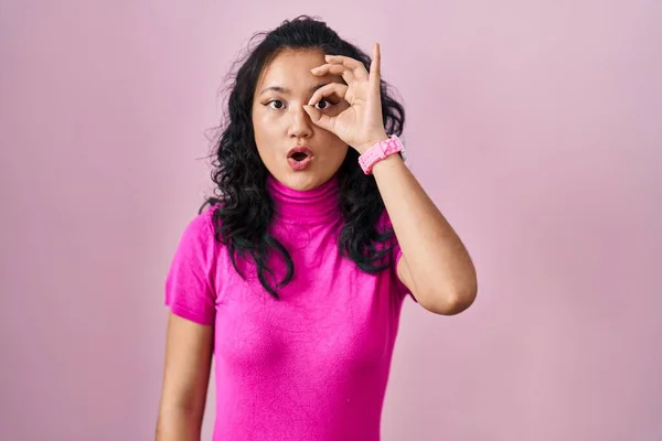 Молодая Азиатка Стоящая Розовом Фоне Делает Нормальный Жест Потрясенный Удивленным — стоковое фото